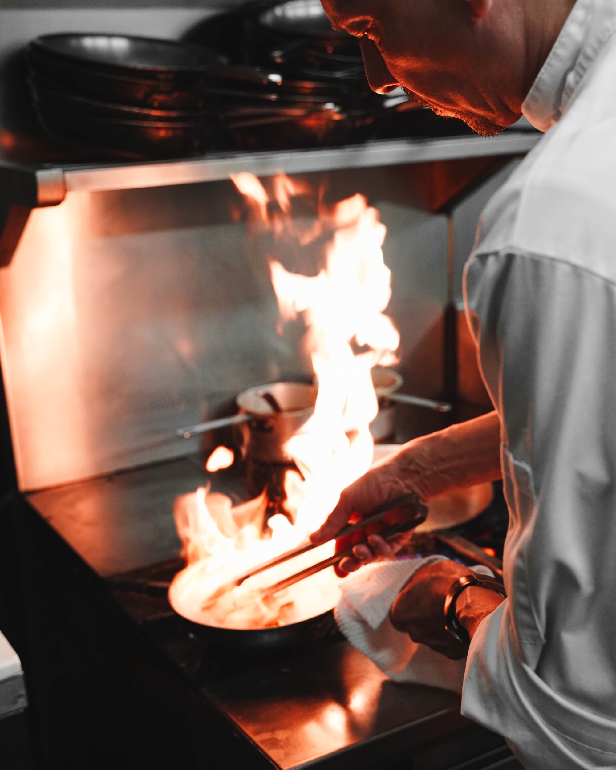 A restaurant chef cooking over the stove
