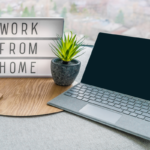 remote work setup with laptop and work from home sign