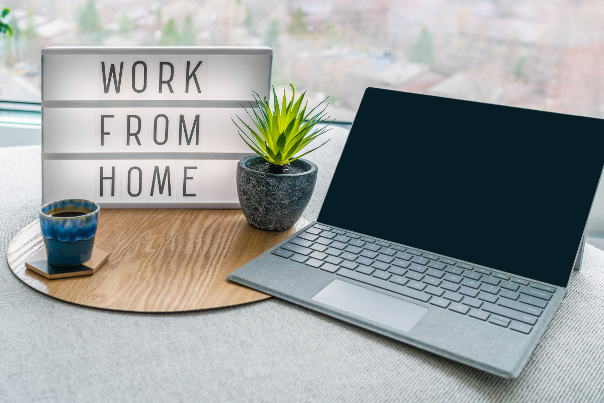 remote work setup with laptop and work from home sign